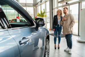 Beautiful couple in car dealership chooses car