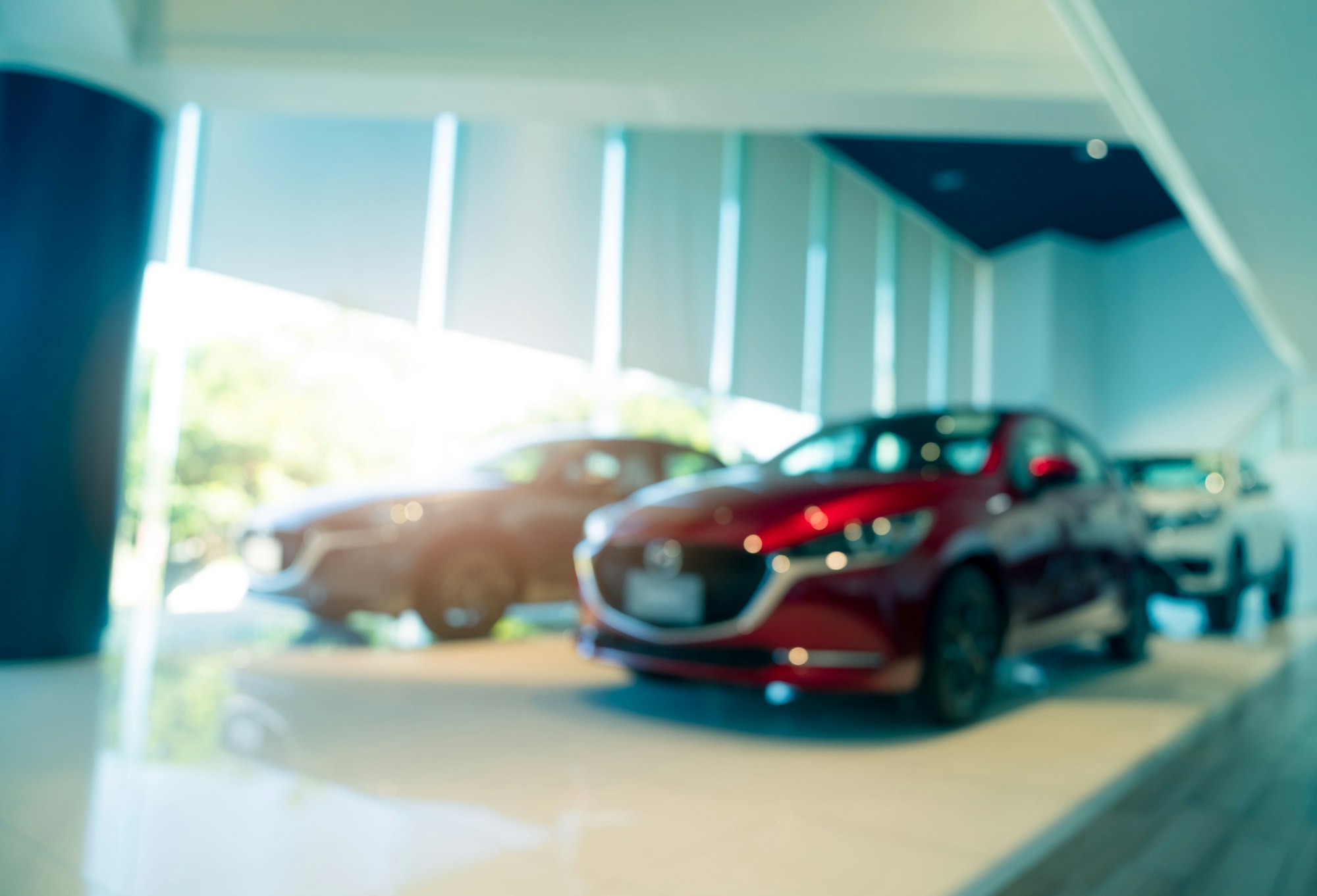 Blurred SUV car parked in modern showroom. Car dealership and auto leasing concept. Automotive indus